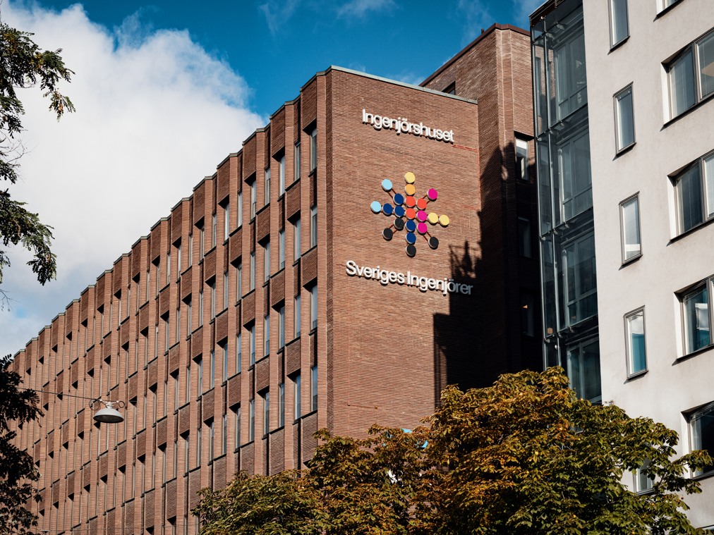 A tall brick building with a sign on the side of it.