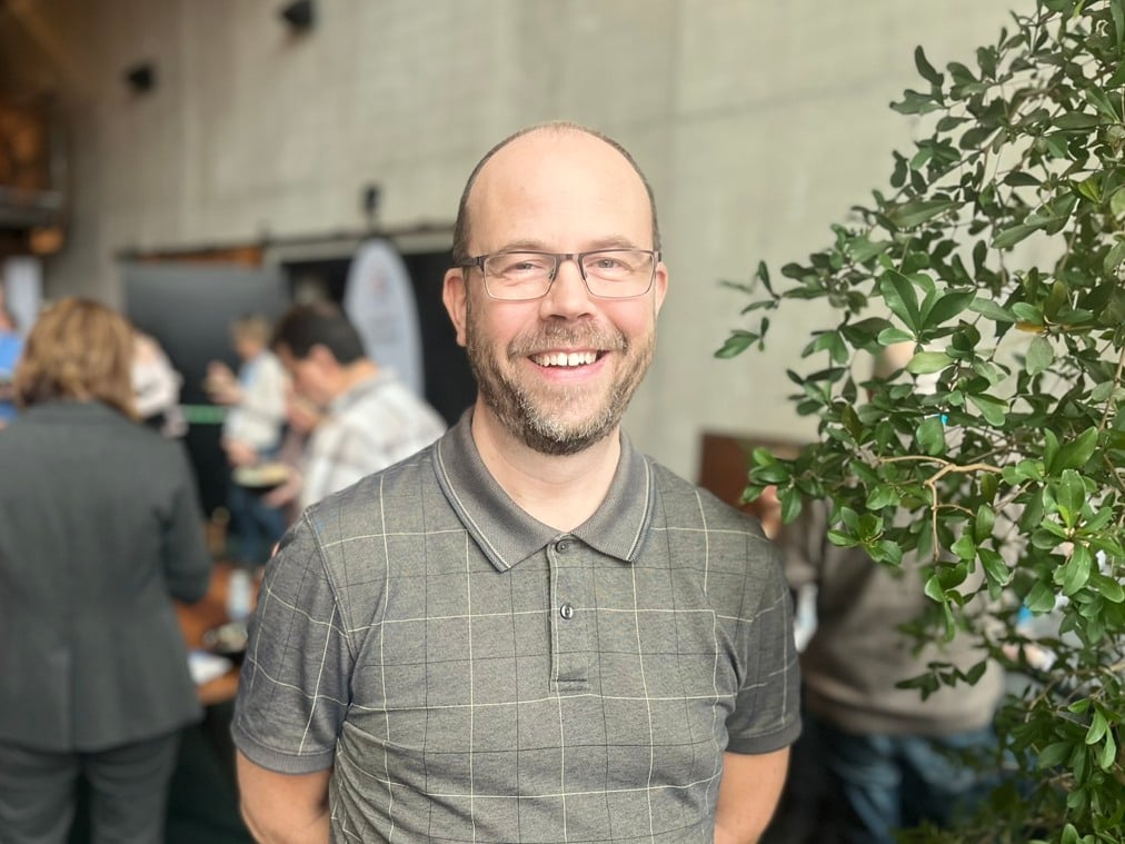 En person står framför ett träbord.